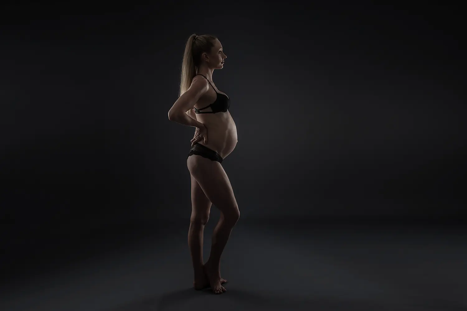 Pregnant woman against dark background