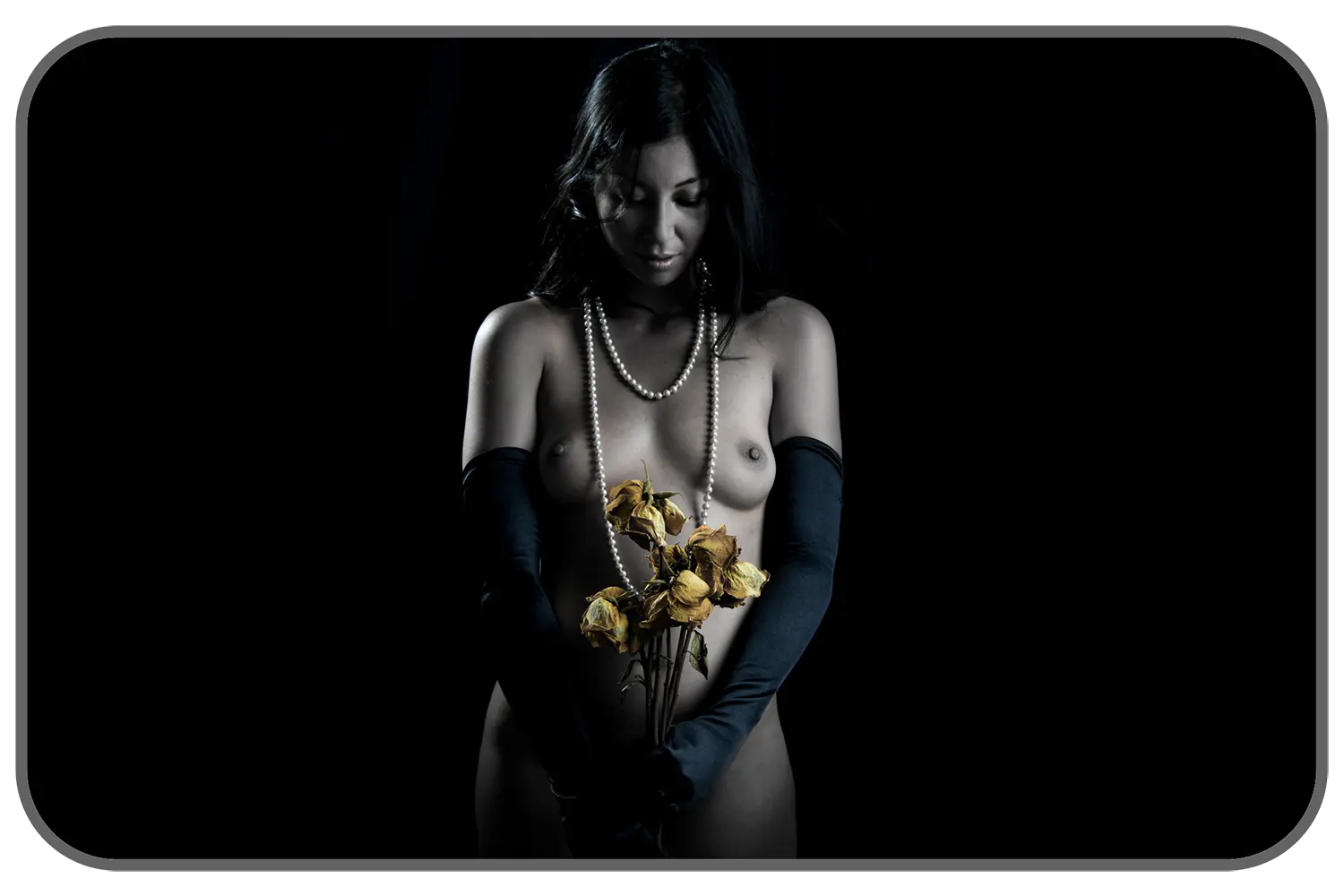 Nude woman wearing gloves and holding flowers