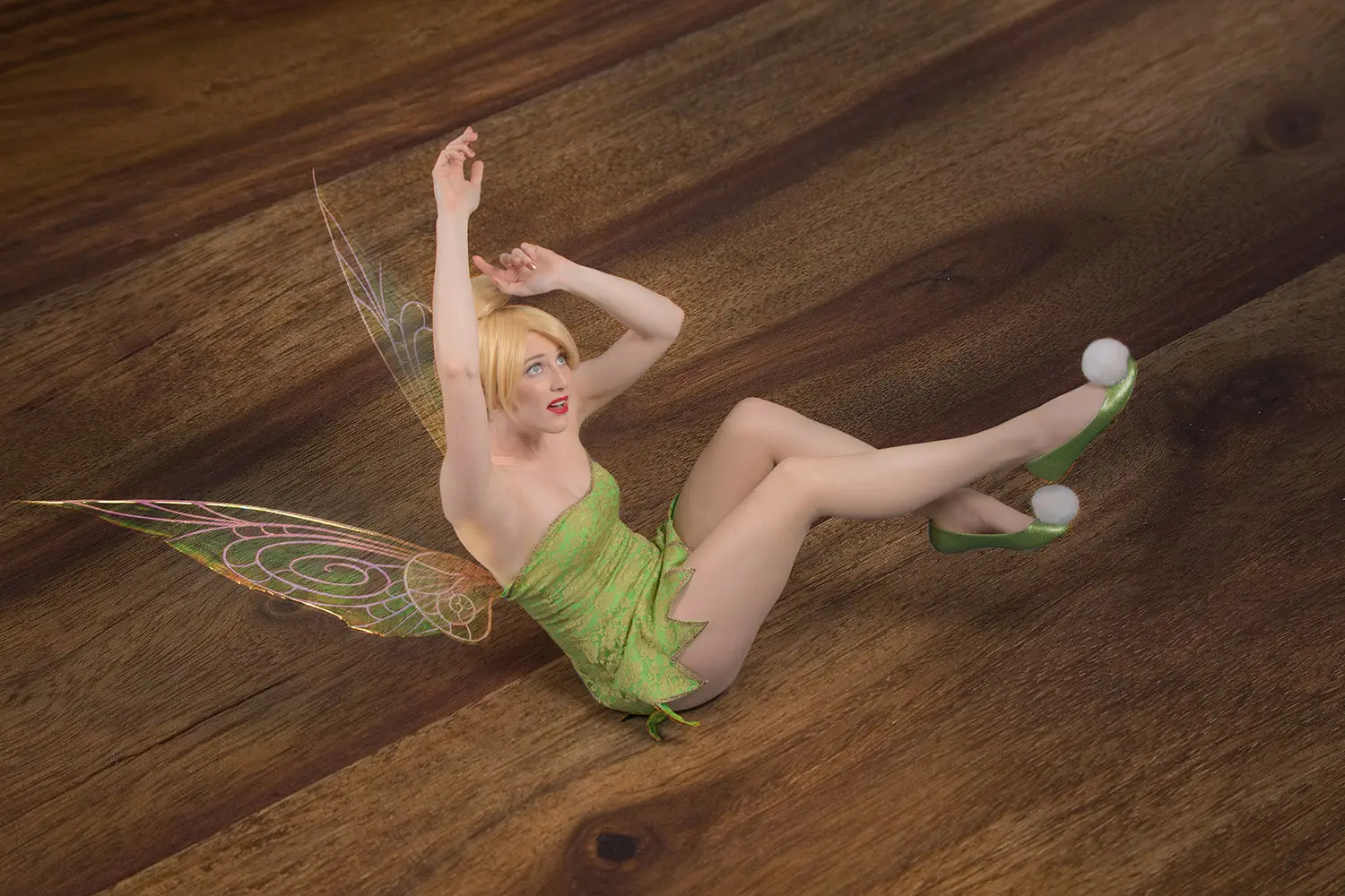 Cosplay Tinkerbell Fairy falling backwards onto table with giant's shadow